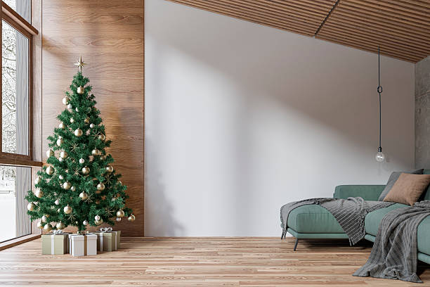 istock A cozy modern interior in a log cabin, with a decorated Christmas tree placed beside large windows with a snowy outdoor view, an empty white wall and copy space in the middle, a green sofa, a hanging light in the corner 2249355936