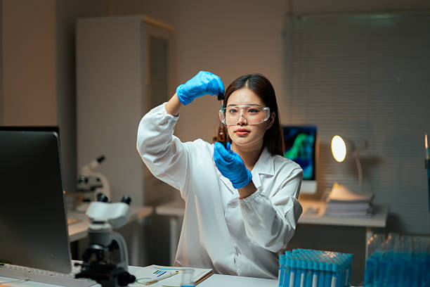 Focused researcher wearing protective eyewear and gloves performing a scientific experiment in a lab environment