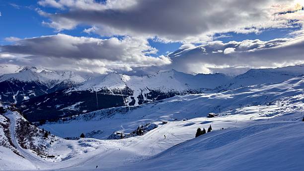 istock Snow-covered mountains under a bright blue sky with scattered clouds during winter season near ski slopes, Austria 2249361042