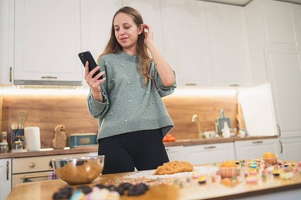 istock Holiday Baking Preparation – Woman Looking Up Gingerbread Inspiration 2249361292
