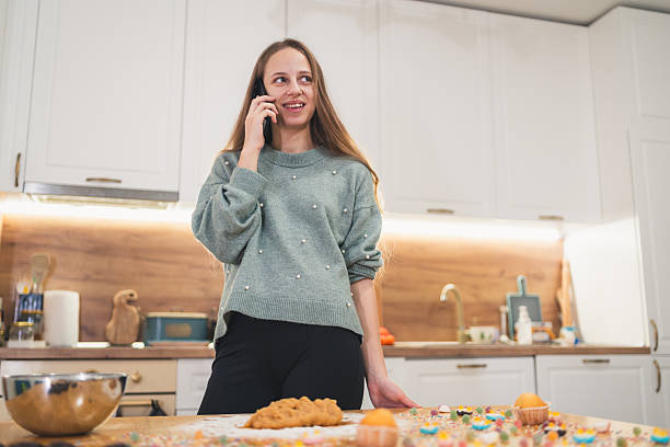 istock Woman Talking on the Phone While Gingerbread Dough Rests on Table 2249361296