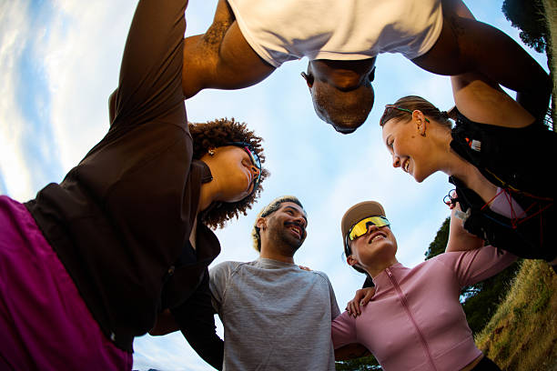 Large group of happy athletic friends having fun while taking a selfie with mobile phone in the park.