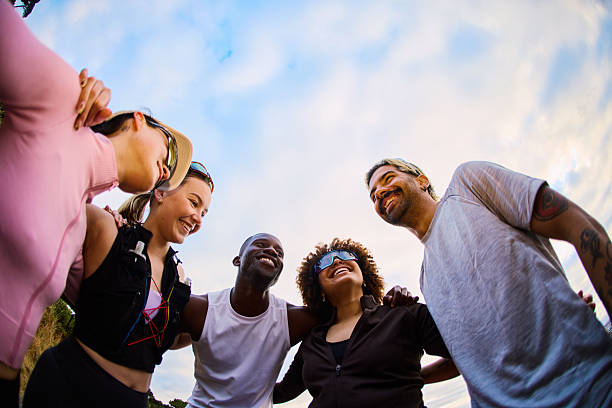 Cheerful diverse group of friends and family members posing together outdoors. Multicultural community enjoying time together, representing unity and inclusivity in natural setting.