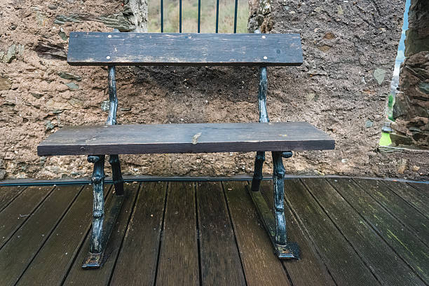 istock Weathered bench sits peacefully against ancient stone walls at a quiet historic site 2249365268
