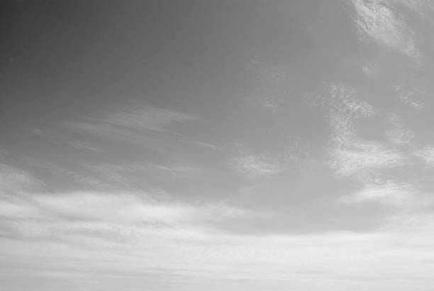 Sky background. Black and white sky background. Grey blurred texture. Sky with little clouds.