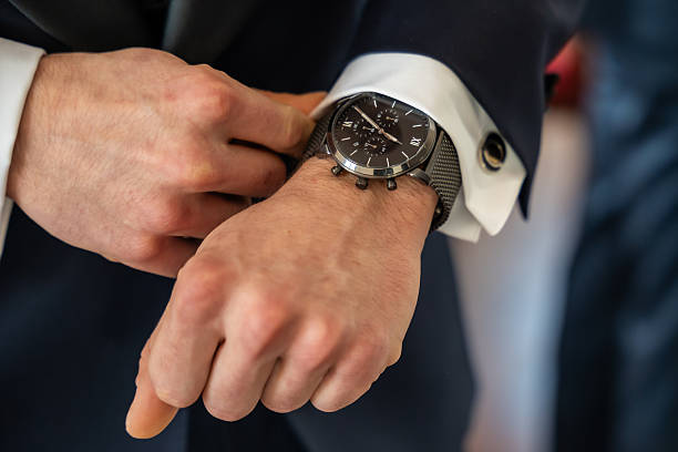istock Groom Adjusting Wristwatch On Suit Sleeve During Wedding Preparation In Elegant Setting 2249365739