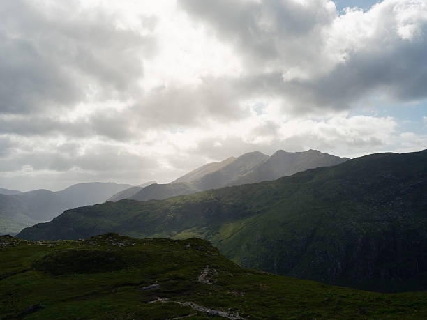 istock Dramatic mountain panorama. Lush green slopes meet a partly cloudy sky. The image conveys a sense of awe and wonder at the power of nature. 2249366380