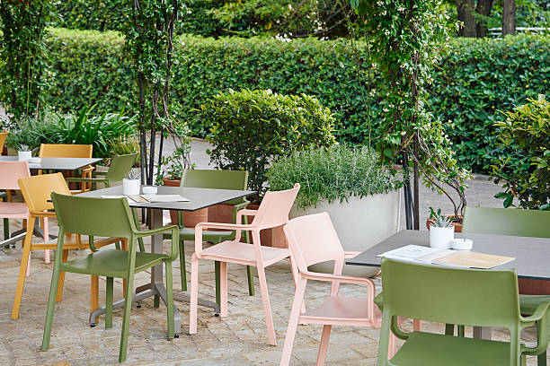istock Outdoor Dining Area with Colorful Chairs and Lush Greenery Creating a Relaxing Atmosphere for Guests to Enjoy Meals in Nature's Embrace 2249369013