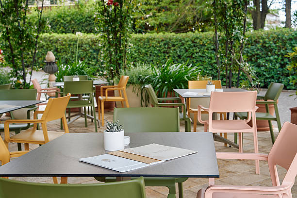 istock A Serene Outdoor Dining Space Surrounded by Lush Greenery with Colorful Chairs and Tables Set for a Relaxing Meal Experience 2249369677