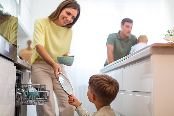 istock Family helping with kitchen chores loading dishwasher 2249369787