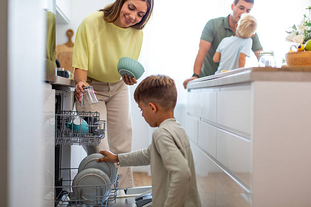 istock Family parents and children unloading dishwasher together in kitchen 2249369791