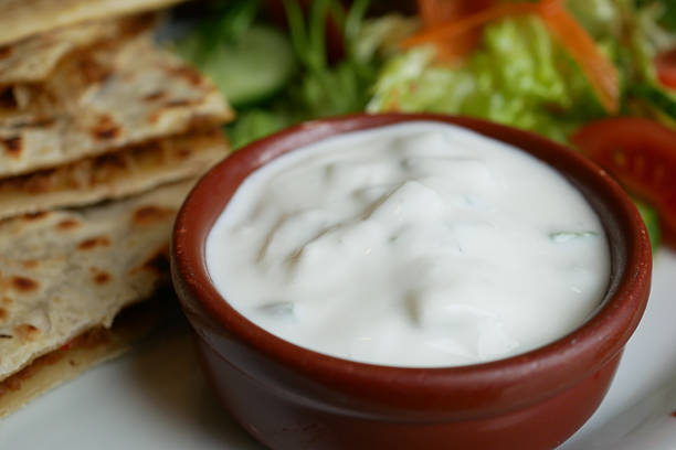 Creamy yogurt dip presented with flatbread and vibrant salad greens.