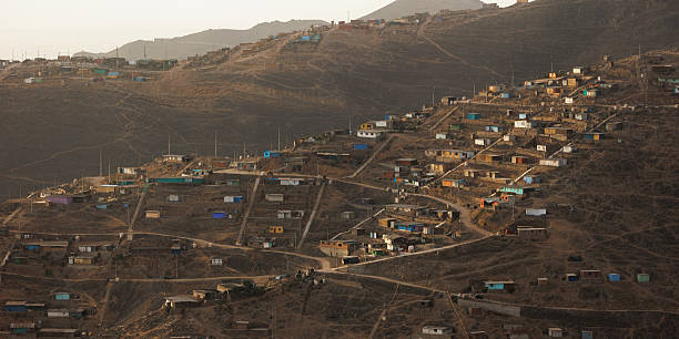 istock Densely packed colorful houses stacked on a steep arid hill featuring long concrete stairs, illustrating urban overcrowding, poverty, and informal architecture in Lima, Peru 2249371347