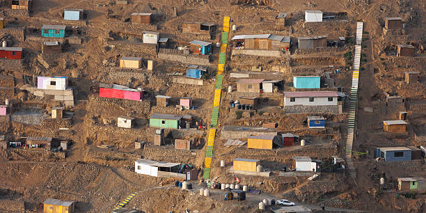 istock Densely packed colorful houses stacked on a steep arid hill featuring long concrete stairs, illustrating urban overcrowding, poverty, and informal architecture in Lima, Peru 2249371363
