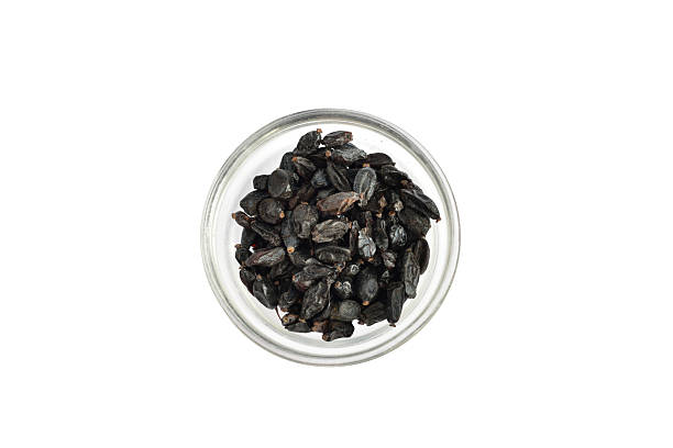 Dried barberries lie in a round vase. View from above