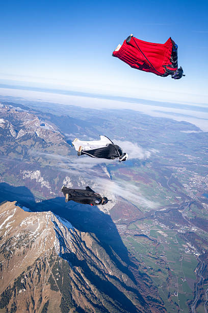 istock Wingsuit fliers fly in formation over snowcapped mountains 2249371532