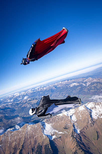 istock Wingsuit fliers fly face to face over snowcapped mountains 2249371582