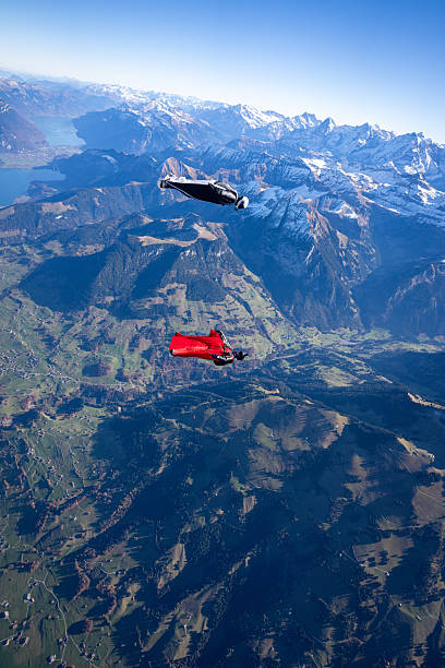 istock Wingsuit fliers fly face to face over snowcapped mountains 2249371602