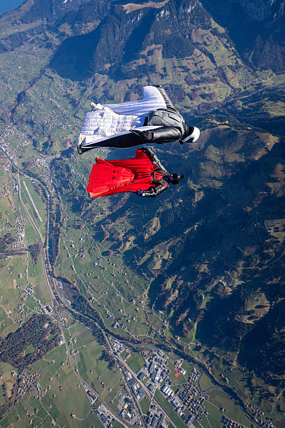 istock Wingsuit fliers fly face to face over snowcapped mountains 2249371638