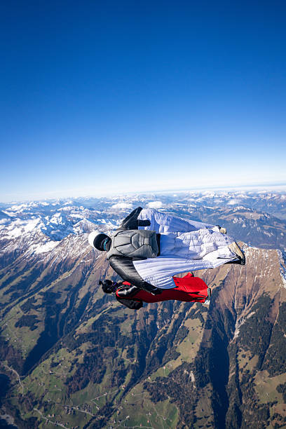 istock Wingsuit fliers fly face to face over snowcapped mountains 2249371669