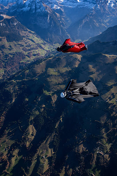 istock Wingsuit fliers fly side by side over snowcapped mountains 2249372658