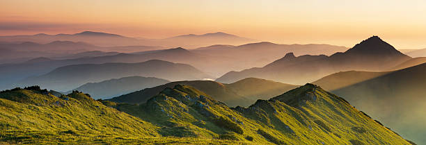istock Green mountains in a misty, hazy sunrise. 2249372688