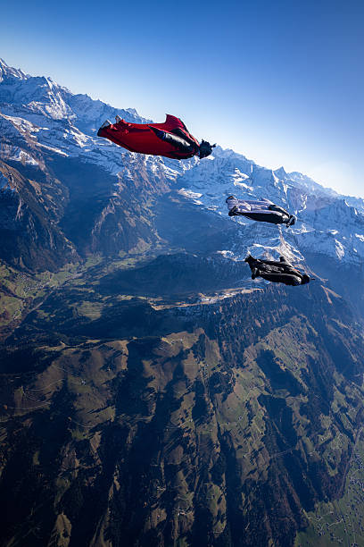 istock Wingsuit fliers fly in formation over snowcapped mountains 2249372822