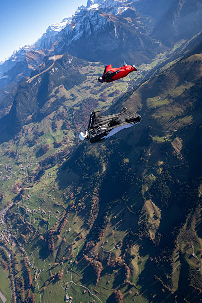 istock Wingsuit fliers fly side by side over snowcapped mountains 2249372828