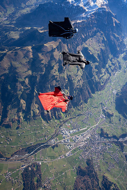 istock Wingsuit fliers fly in formation over snowcapped mountains 2249373531
