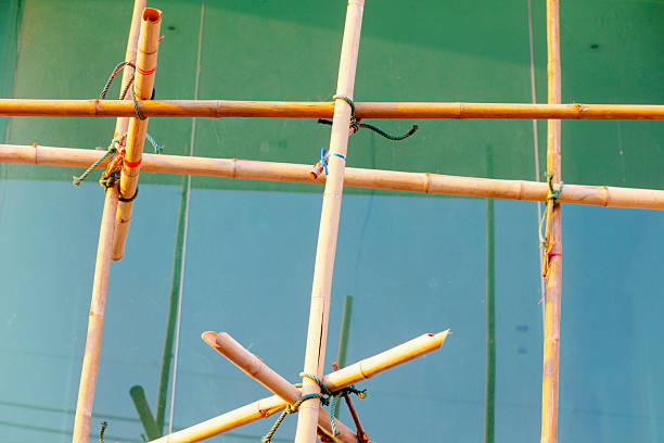 Large modern home window behind bamboo scaffolding of new home under construction   in residential district of Bangkok Ladprao