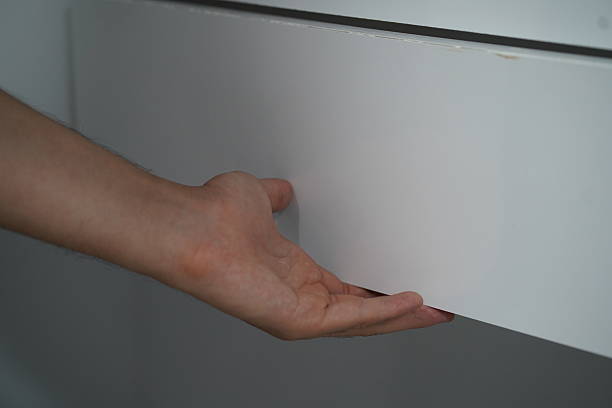 istock Close Up of a Hand Reaching for a White Drawer with Smooth Surface in a Minimalistic Interior Setting for Stylish Home Organization 2249374386