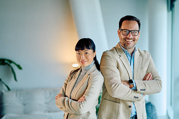 istock Business colleagues standing back to back smiling in office 2249378517