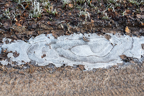 A small icy puddle on a dirt road on a cold winter day