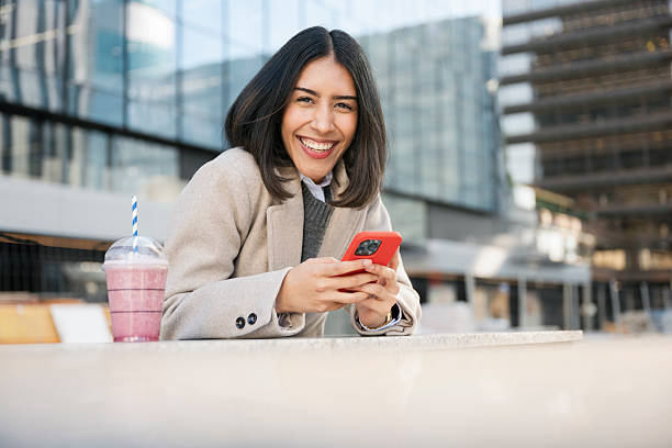 istock Happy young woman using smartphone in city 2249380384