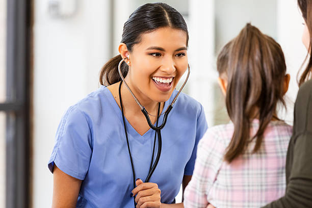 istock Joyful doctor interacts with young patient and mother using stethoscope in a bright examination room. 2249380527