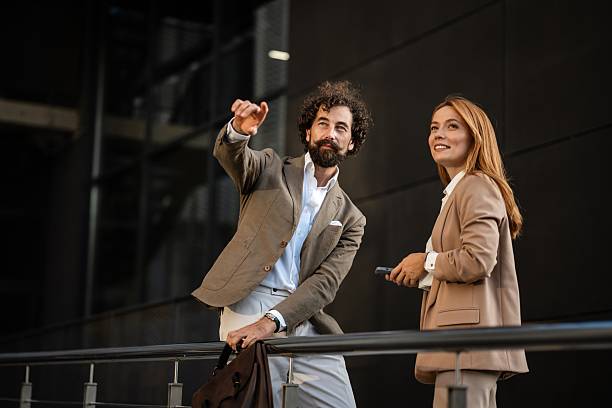 istock Businessman pointing while explaining something to colleague outdoors 2249381329