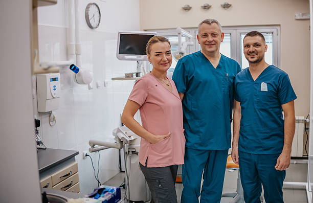istock Dentist and staff smiling together in a modern dental office during working hours 2249385874