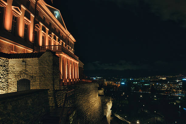 Illuminated Stenbock House, seat of the Estonian Government, atop the limestone walls of Toompea Hill in Tallinn at night.