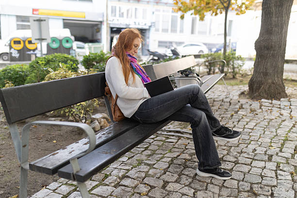 istock Young woman writing, studying on park bench 2249387667