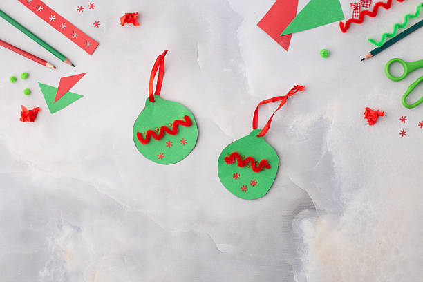 The child makes a paper Christmas decoration. Made with his own hands. Step by step instruction. Children's art project craft for kids. Craft for children. Top view High quality photo