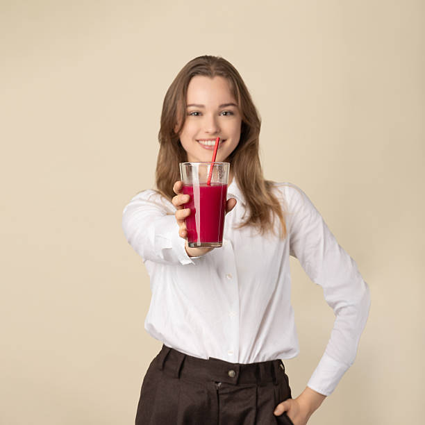 istock Beautiful woman drinking red juice with straw 2249390377