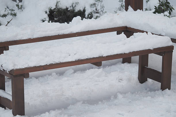 istock Snow covers a wooden bench in a winter garden setting 2249395652