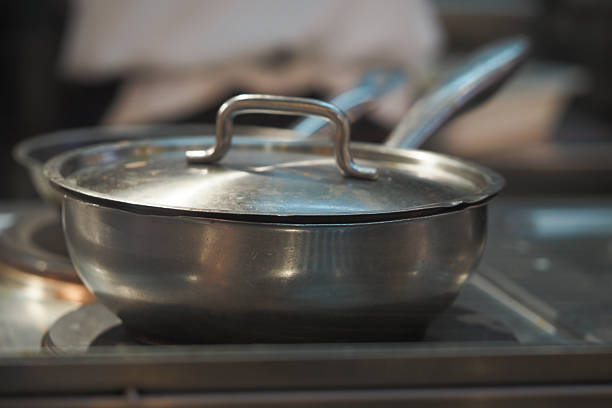 A stainless steel cooking pot is placed on the stove, ready for use.