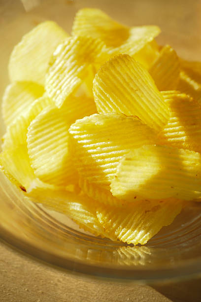 istock Crispy yellow potato chips in a clear bowl 2249398589