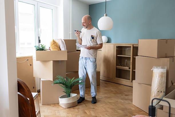istock Man is organizing moving boxes while talking on the phone 2249400459