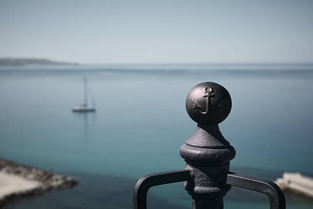 Discover the allure of a weathered, rusty dock standing resilient against the backdrop of the expansive blue sea.