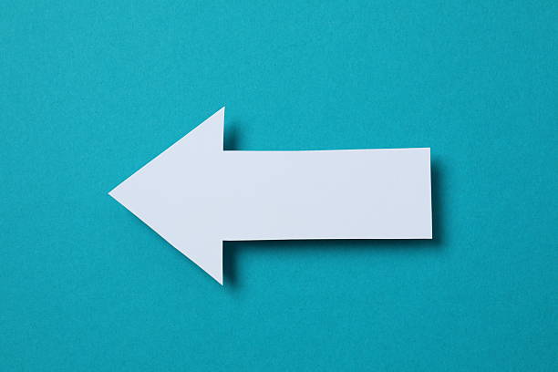 Paper arrow on color background, top view