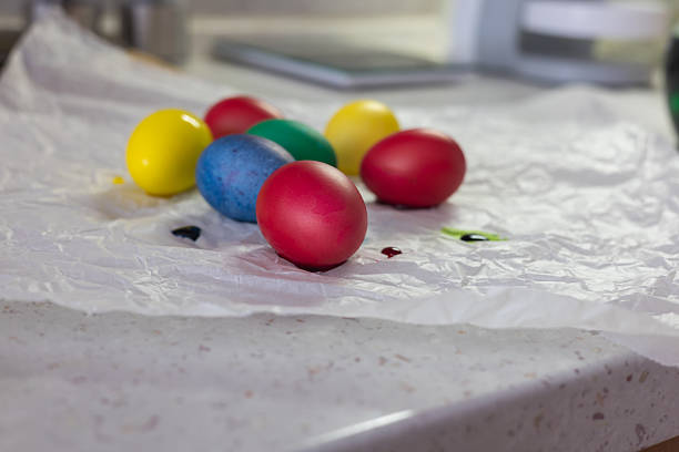 Brightly colored Easter eggs  various colors - green, yellow, red, blue  arranged on crumpled white paper. The eggs are smooth and shiny, ready for decoration or display at Easter.
