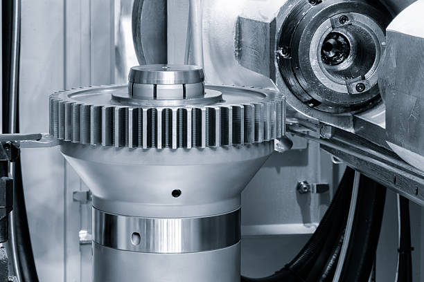 Modern multifunctional CNC metalworking machine with finished round part with gear, industrial concept.