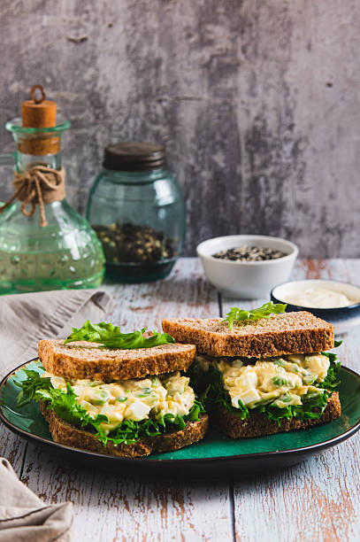 istock Savory egg salad sandwich with avocado on whole grain bread on a plate vertical view 2249406933